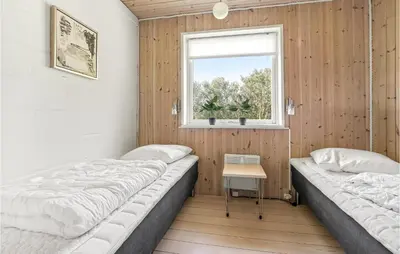 two beds in a room with a window at Holiday Home Gunhildsvej Vestervig Xii in Vestervig