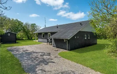 a house with a black roof and a gravel driveway at Holiday Home Gunhildsvej Vestervig Xii in Vestervig