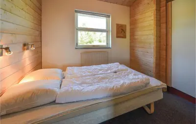 a large bed in a room with a window at Awesome Home In Spøttrup With Sauna in Spottrup