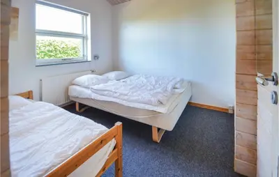 two beds in a small room with a window at Awesome Home In Spøttrup With Sauna in Spottrup