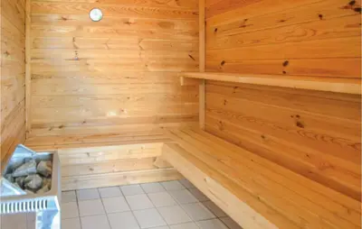 a sauna with wooden walls and a white tile floor at Awesome Home In Spøttrup With Sauna in Spottrup