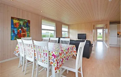 a dining room with a table and white chairs at Holiday Home Strandlyst Vinderup Vi in Vinderup