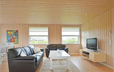 a living room with a couch and a tv at Holiday Home Strandlyst Vinderup Vi in Vinderup