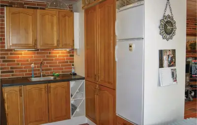 a kitchen with a white refrigerator and wooden cabinets at Awesome Home In Spøttrup With Wifi in Spottrup
