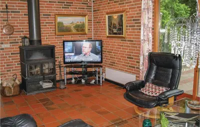 a living room with a television and a brick wall at Awesome Home In Spøttrup With Wifi in Spottrup