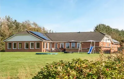 a house with a playground in front of it at Stunning Home In Spøttrup With Sauna in Spottrup