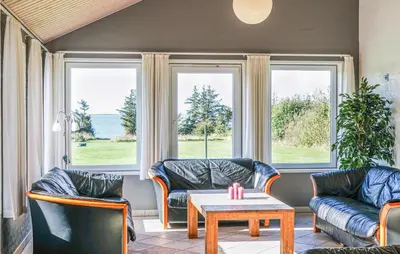 a living room with couches and a table and windows at Stunning Home In Spøttrup With Sauna in Spottrup