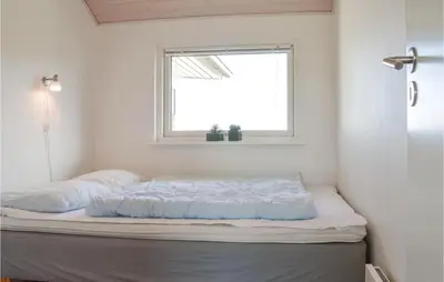 two beds in a room with a window at Holiday Home Astersvej in Lemvig