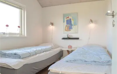 two beds in a room with a window at Holiday Home Astersvej in Lemvig