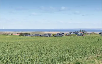 a field of green grass with houses in the background at Holiday Home Astersvej in Lemvig