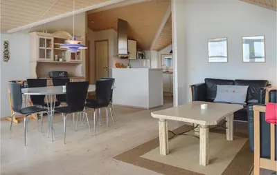 a living room and kitchen with a table and chairs at Holiday Home Skovstjernevej Lemvig Ii in Lemvig