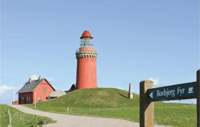a lighthouse on top of a hill with a street sign at Holiday Home Skovstjernevej Lemvig Ii in Lemvig