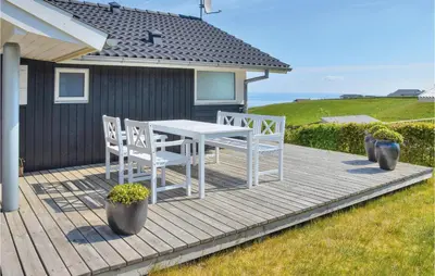 a wooden deck with a table and chairs on a house at Holiday Home Skovstjernevej Lemvig Ii in Lemvig