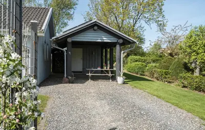 a garage with a picnic table in front of a house at Holiday Home Sommerstedvej Denm in Vinderup
