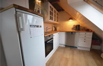 a kitchen with white cabinets and a refrigerator at Apartment Lysenvej in Roslev