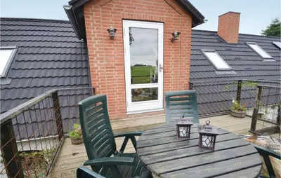 a wooden table and chairs on a deck at Apartment Lysenvej in Roslev