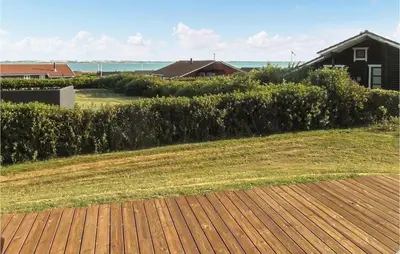 a hedge in front of a yard with a house at Holiday Home Lerskrænten Vinderup I in Vinderup