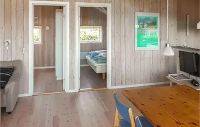 a living room with a television and a room with a bed at Holiday Home Lerskrænten Vinderup I in Vinderup