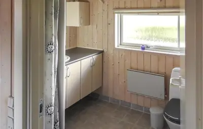 a bathroom with a sink and a toilet and a window at Holiday Home Lerskrænten Vinderup I in Vinderup