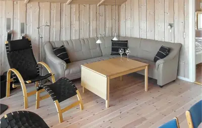 a living room with a couch and a table and chairs at Holiday Home Lerskrænten Vinderup I in Vinderup