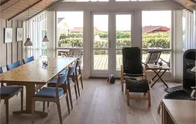 a dining room with a table and chairs and windows at Holiday Home Lerskrænten Vinderup I in Vinderup