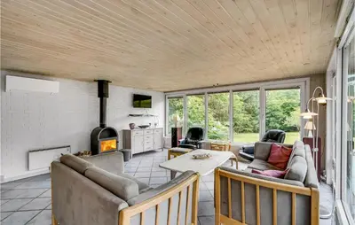 a living room with a couch and a table at Holiday Home Skibstedvej Hurup Thy in Sønder Ydby
