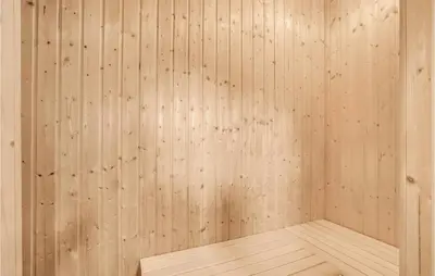 an empty sauna with wooden walls and a wooden floor at Holiday Home Skovvej Thyholm Xii in Thyholm