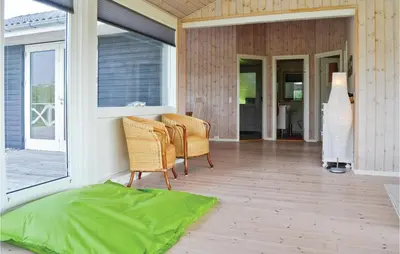 a screened in porch with two chairs and a window at Holiday Home Kalkstensvej in Spottrup