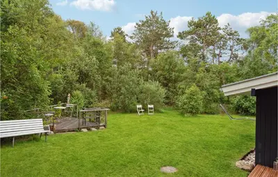 a yard with a bench and a playground at Holiday Home Hærvej Thyholm Xi in Thyholm