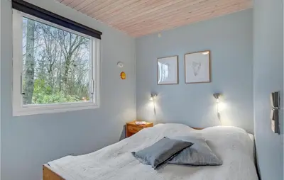 a bedroom with a bed and a window at Holiday Home Hærvej Thyholm Xi in Thyholm