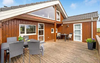 a wooden deck with a table and chairs at Lovely Home In Thyholm With Sauna in Thyholm