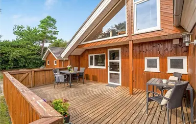 a wooden deck with a table and chairs on a house at Lovely Home In Thyholm With Sauna in Thyholm