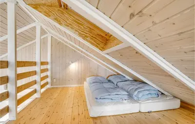 a bed in a room with a wooden ceiling at Lovely Home In Thyholm With Sauna in Thyholm