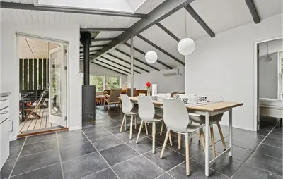 a kitchen and dining room with a table and chairs at Strandbo in Thyholm