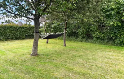 a hammock hanging between two trees in a yard at Holiday Home Strandlyst Vinderup I in Vinderup