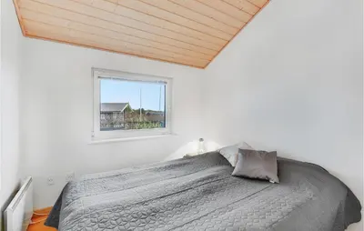 a white bedroom with a bed and a window at Holiday Home Kildebakken Vinderup V in Vinderup