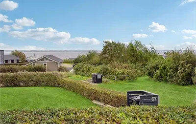 a yard with green grass and two trash cans at Holiday Home Lerskrænten Vinderup Xi in Vinderup