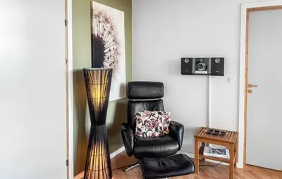 a black chair and a vase in a room at Holiday Home Lerskrænten Vinderup Xi in Vinderup