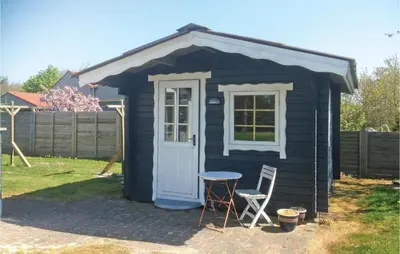 a small black shed with a table and two chairs at Holiday Home Lærkevej Vinderup Xii in Vinderup