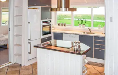 a kitchen with white cabinets and a counter top at Holiday Home Houmøllevej in Karby