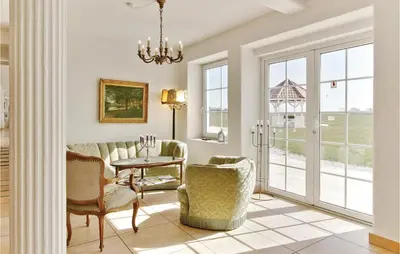 a living room with a couch and chairs and a table at Bakkegården in Vesløs