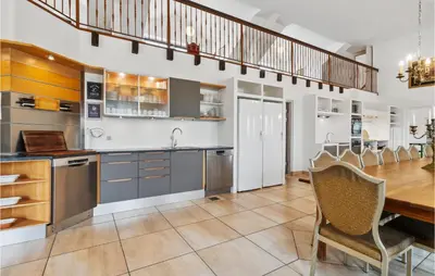a kitchen with a table and a dining room at Bakkegården in Vesløs