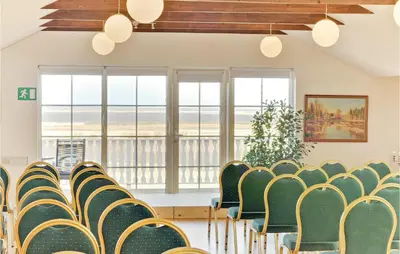 a room with chairs and tables and windows at Bakkegården in Vesløs