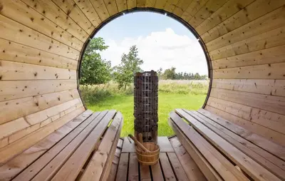 an inside view of a wooden sauna with a round window at Holiday Home Ballesvej in Øster Assels