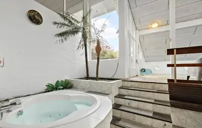 a bathroom with a tub and a palm tree at Stunning Home In Roslev With Sauna in Roslev