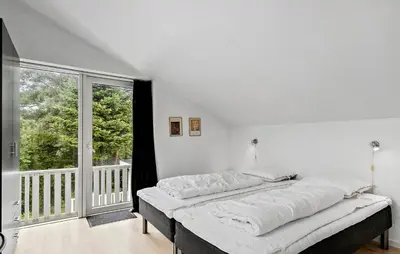 a bed in a room with a large window at Stunning Home In Roslev With Sauna in Roslev