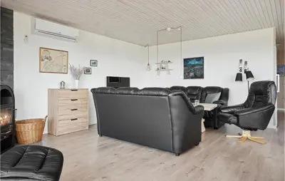 a living room with black leather chairs and a desk at Holiday Home Limfjordsvangen Snedsted X in Snedsted