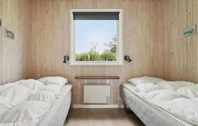 two beds in a room with a window at Holiday Home Limfjordsvangen Snedsted X in Snedsted