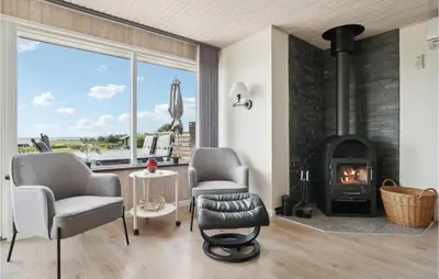 a living room with two chairs and a fireplace at Holiday Home Limfjordsvangen Snedsted X in Snedsted