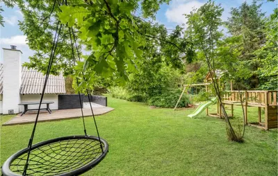a swing in a yard with a playground at Holiday Home Klydevej Hurup Thy Xi in Sindrup